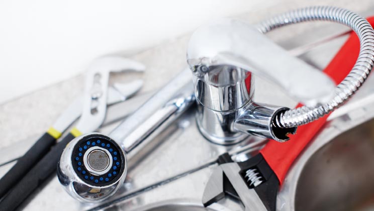 Wrenches and other plumbing tools by faucet